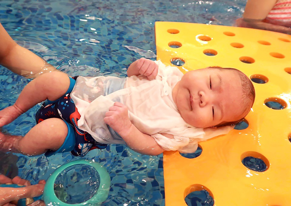 新生兒平躺於特製黃色浮毯上，在不完全沒入水中的安全狀態下，刺激前庭覺發展 (Vestibular System) 並訓練核心平衡感。