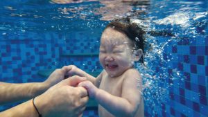 1.5-2.5歲幼兒在大人引導下嘗試潛水，在閉氣過程中展現對大人的高度信任感，這是克服臉部進水恐懼與建立水中適應力的關鍵練習。