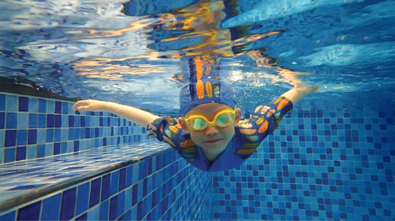 5-8歲兒童在水中自信展現泳姿，此階段課程專注於動作協調性與精確的換氣技巧，為學習標準四式游泳打下穩固基礎。