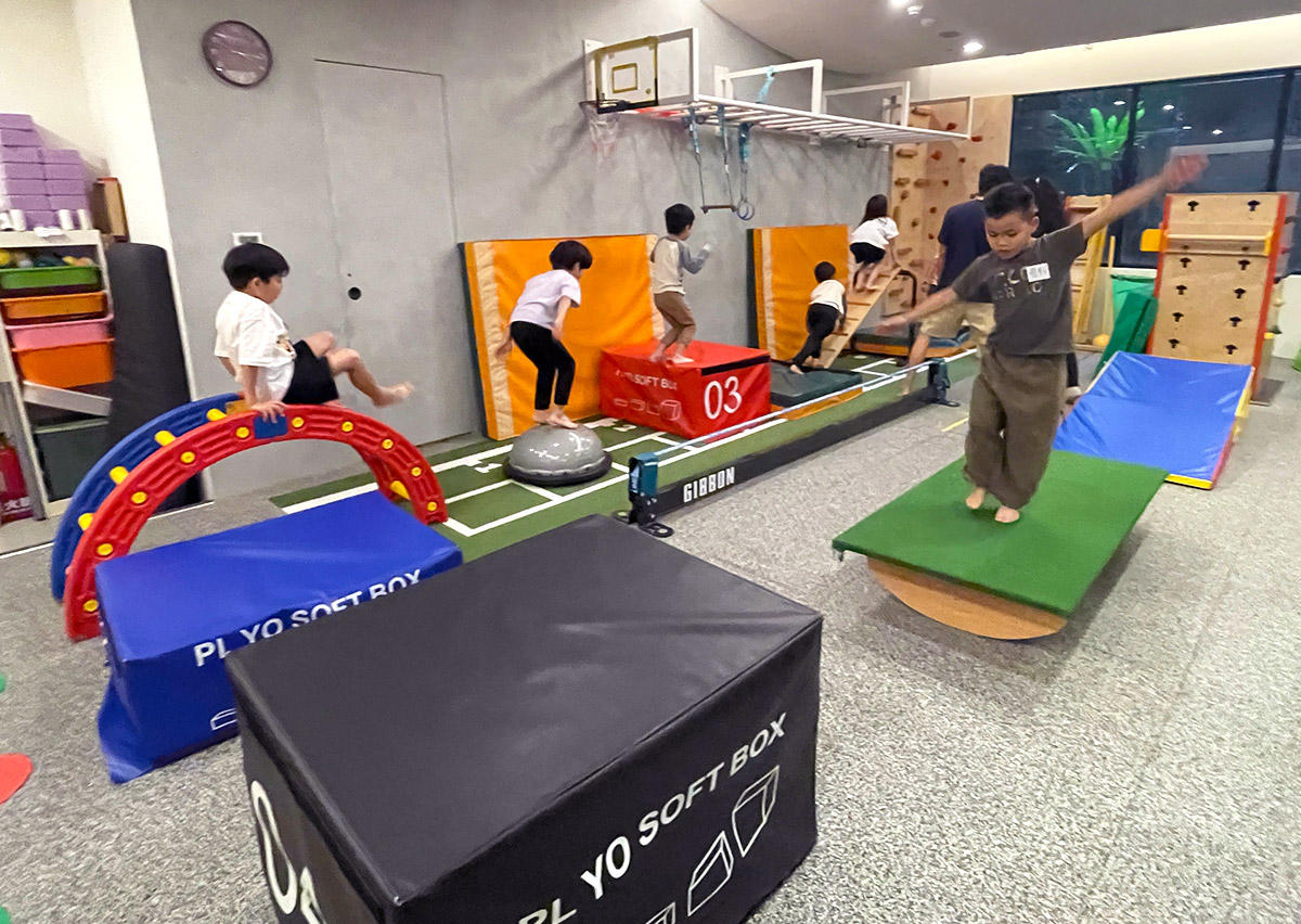Oovi 兒童體能館的障礙賽道 (Obstacle Circuit) 全景，孩子們進行跳躍、平衡與攀爬等多樣化活動，全面提升粗大動作 (Gross Motor Skills) 與心肺耐力。