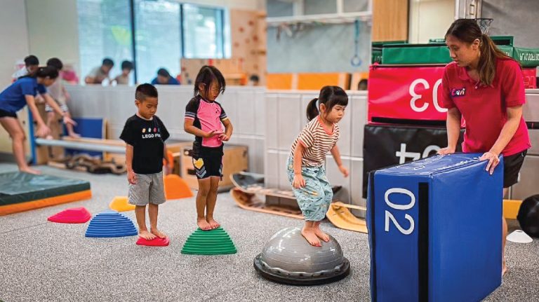 Oovi 老師帶領兒童進行障礙排解 (Obstacle Course) 挑戰，利用平衡球與跳箱訓練孩子的前庭平衡 (Vestibular Balance)、核心穩定度與專注力。