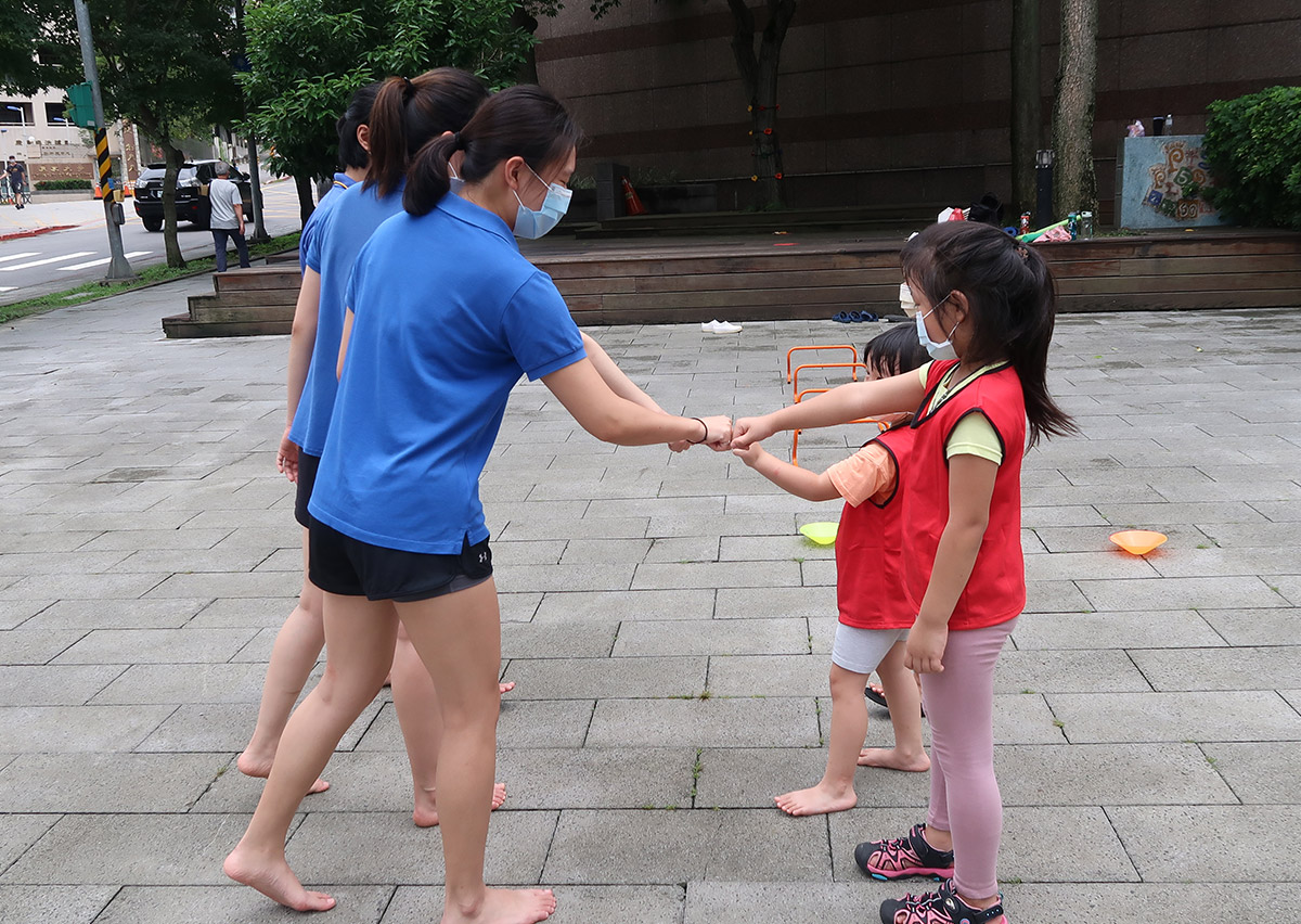 兒童在課程結束後與隊友進行擊拳 (Fist Bump) 互動，這象徵著運動家精神 (Sportsmanship) 的養成，是 Oovi 課程中重視社交情緒學習 (SEL) 與人際尊重的具體實踐。