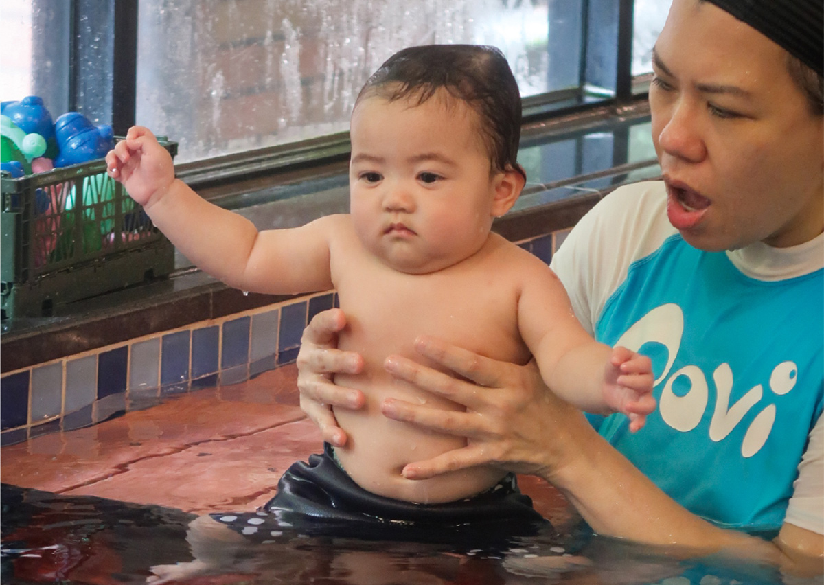 專業教練輔助幼兒在淺水區練習站立與動態平衡，透過專業引導建立孩子對水深變化的適應力與安全感。