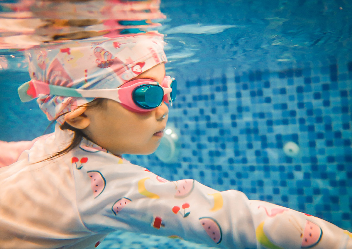 幼兒在水中自信潛水並睜開眼睛，展示熟練的閉氣控制 (Breath Control) 與水中適應力，這是進階游泳課程的重要學習成果。