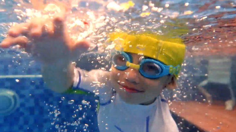 幼兒在水中自信潛水並伸手探索，配戴泳鏡睜大眼睛展現極佳的水中適應力與快樂神情，證明 Oovi 課程能讓孩子在無壓力環境下自然學會閉氣潛水。
