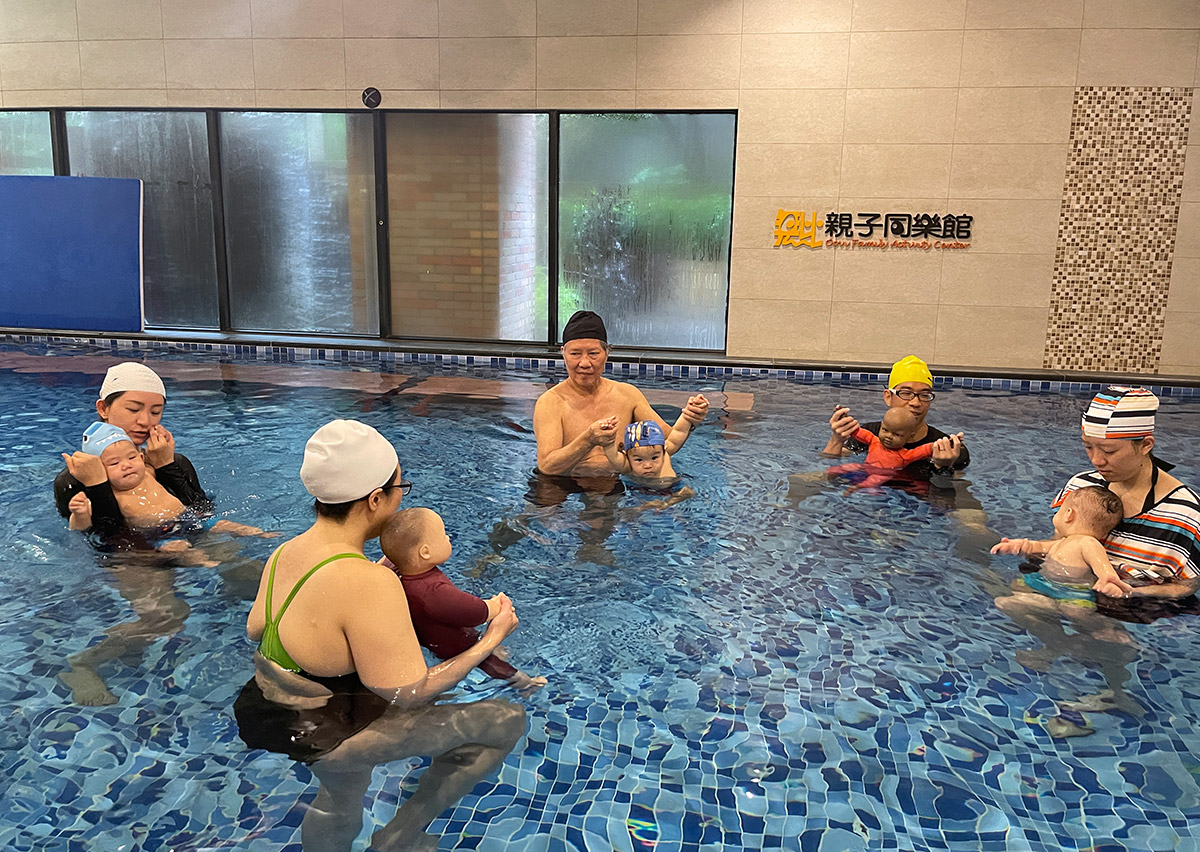 培訓學員與demo baby家庭上課實務練習，示範如何安全支撐嬰兒在水中移動，這是 Birthlight 培訓 重點，確保學員掌握符合人體工學且溫柔的支撐手勢。