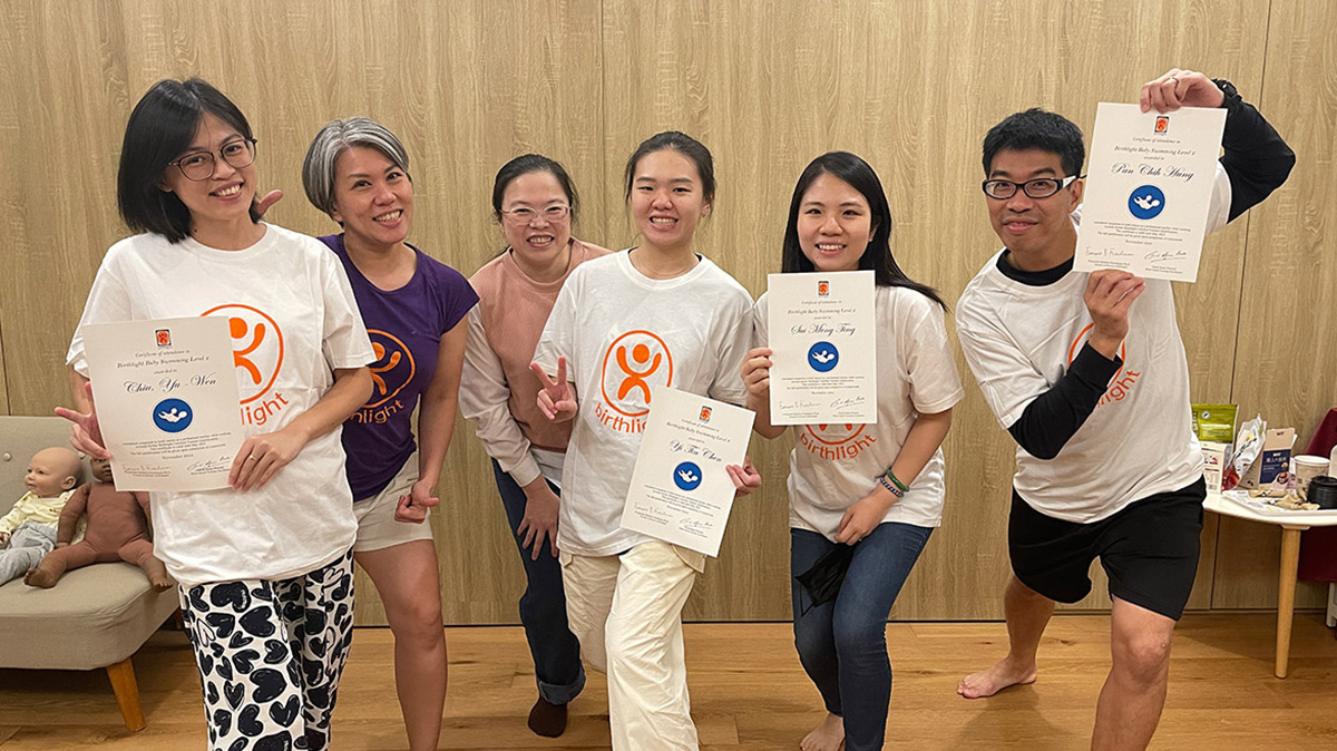 2024 年 Oovi 專業教練團與學員於 Birthlight 英國生之光 培訓課程後，開心地展示 Level 2 國際教師證書。這張合照展現了 Oovi 作為官方認證培訓中心的地位，教練們結合嬰幼兒生理學與心理學，提供全台家長最值得信賴的親水教育服務。