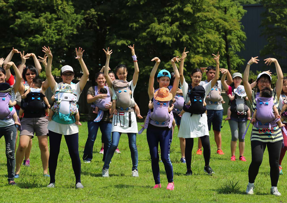 團體揹巾有氧課程中，媽媽們揹著寶寶開心進行全身性運動，這類活動不僅能促進產後修復，更能建立媽媽間的社交支持網絡 (Social Support)，減少育兒孤獨感。