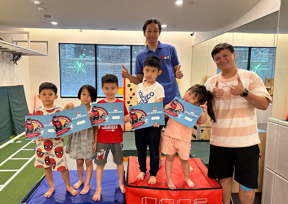 位於台北內湖的Oovi無比親子同樂館暑假營隊，孩童完成階段性訓練後與教練合影並展示證書，透過成就感強化運動學習的正向反饋。