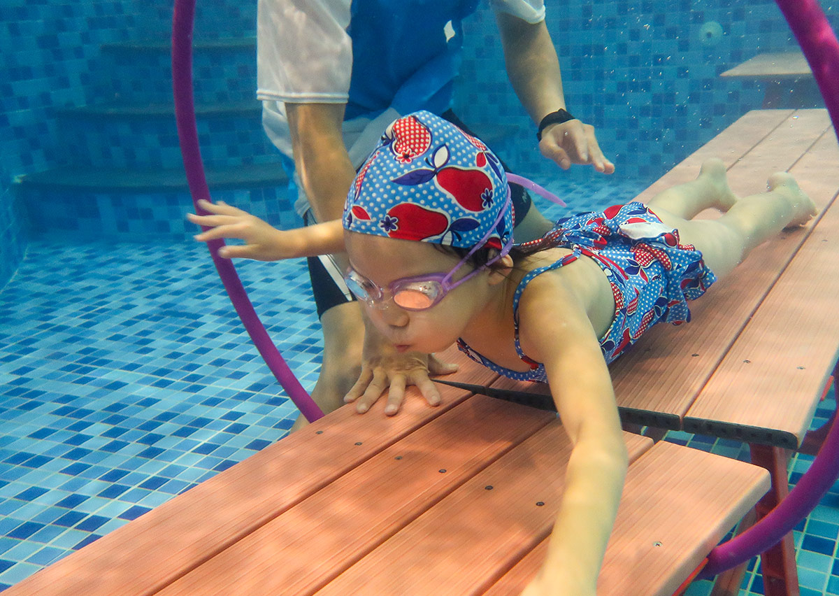 參加 Oovi 寒假營隊的孩子在水下練習穿越圓環，透過水底平台移動掌握氣息控制與流暢水感。