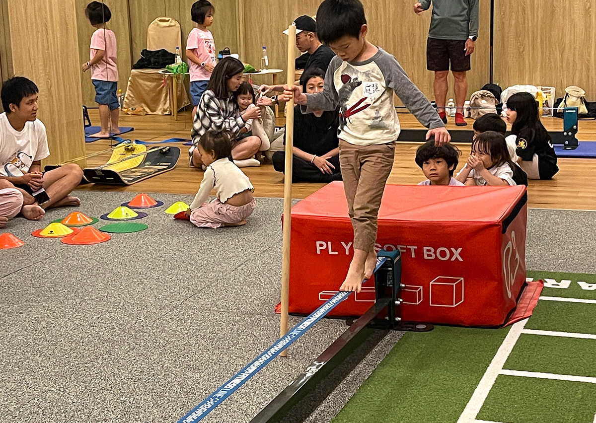 男童在體能教室專注地行走於平衡木 (Balance Beam) 上,這項 FMS 訓練能強化本體感覺 (Proprioception) 與核心穩定度,培養孩子在不穩定環境下的身體控制力。