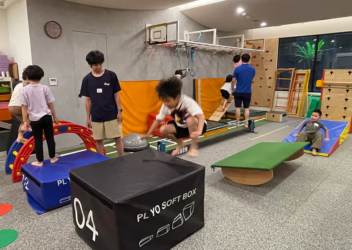 兒童在 Oovi FMS 體能教室進行障礙跨越與跳躍 (Jumping) 練習,模擬跑酷 (Parkour) 動作訓練下肢爆發力,並學習正確的著地緩衝 (Landing Mechanics) 以保護關節。